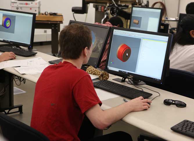 Student looking at a manufacturing part on a computer.